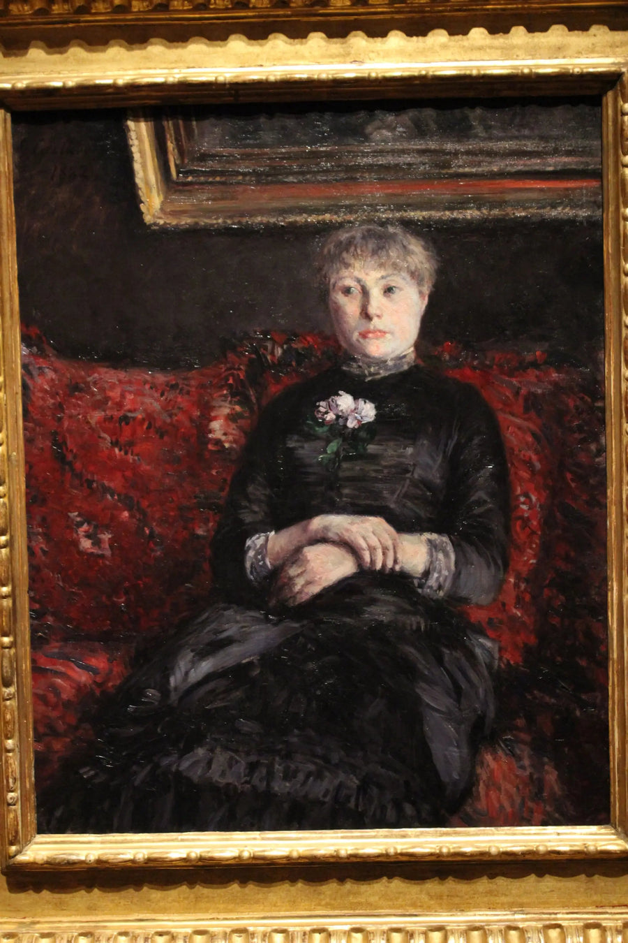 Mulher sentada em um sofá com flores vermelhas - Gustave Caillebotte